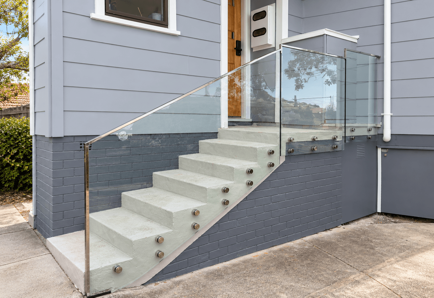 Outdoor stair glass with silver standoffs and a silver frame