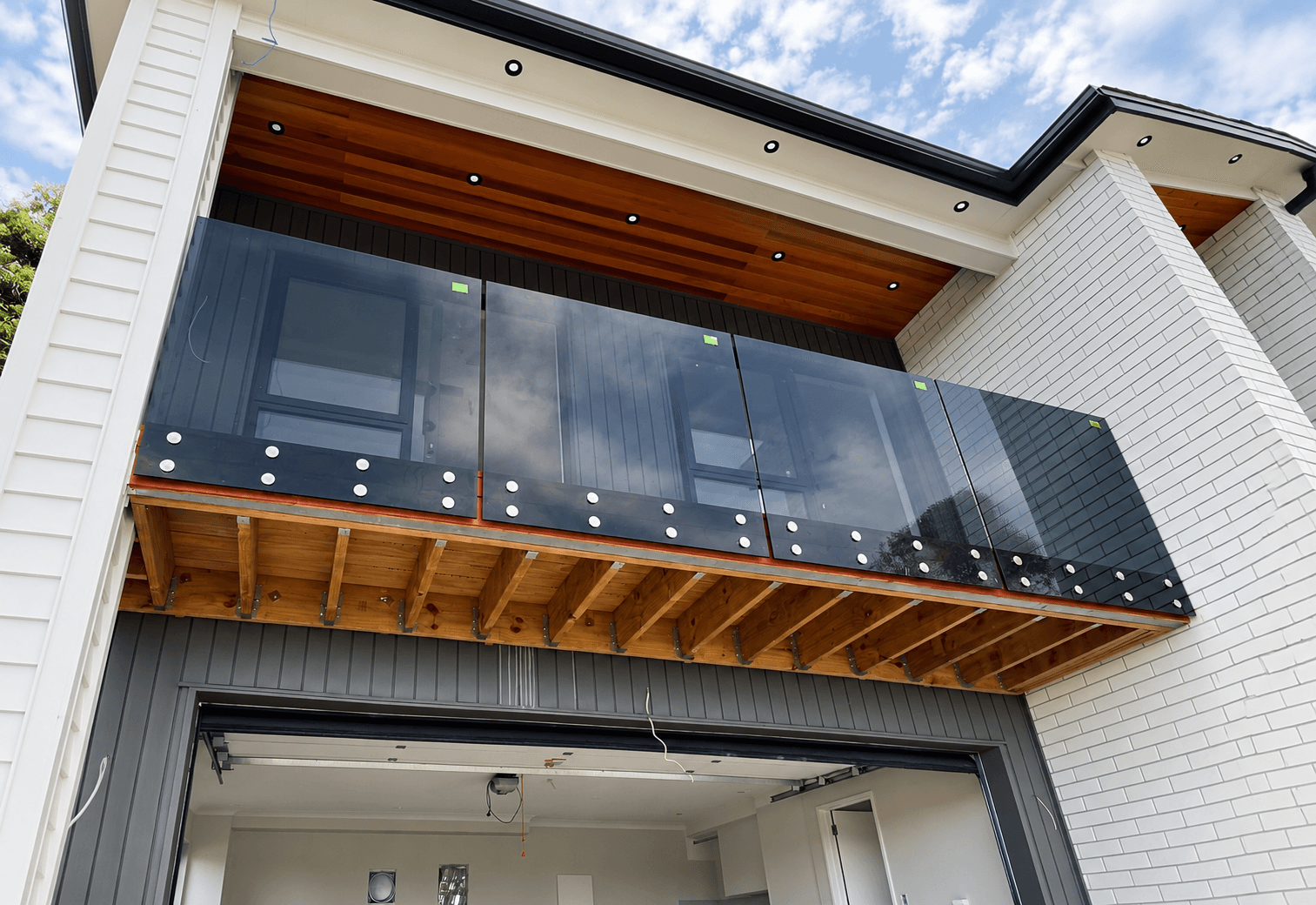 Euro Black glass balustrade with silver standoffs on a balcony