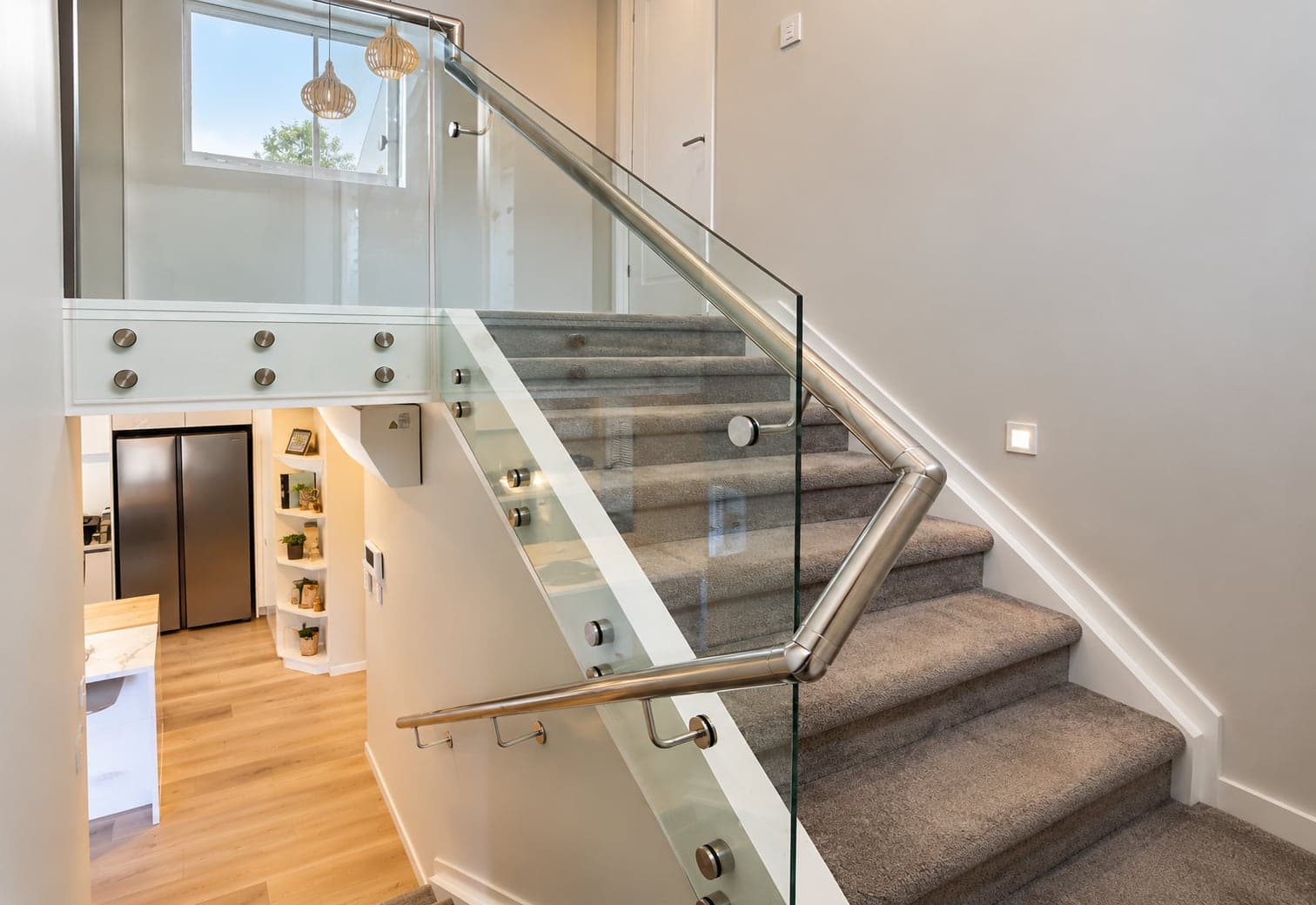 Silver handrail with glass balustrade along indoor stairs
