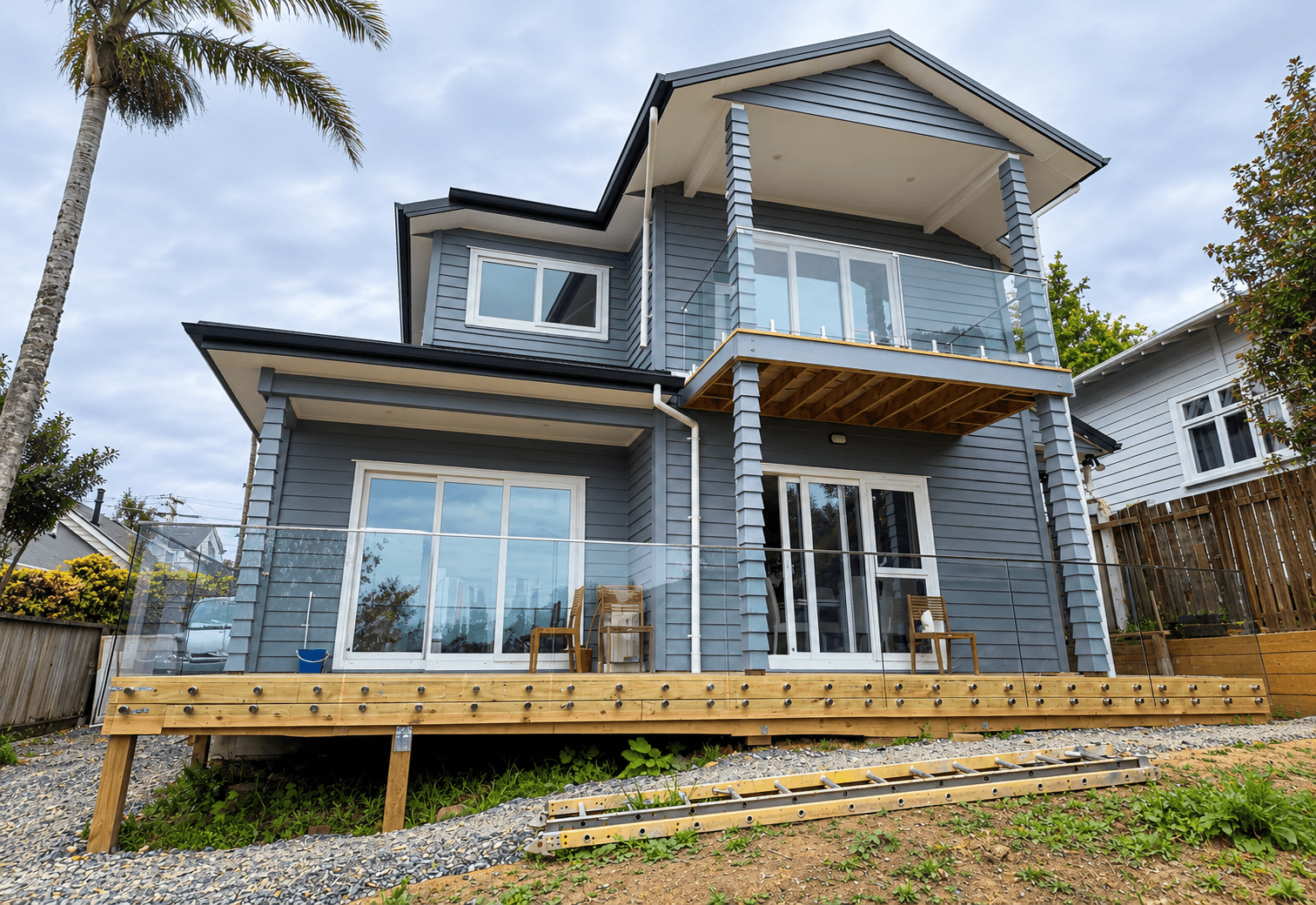 Clear glass balustrade with silver standoffs along a timber deck